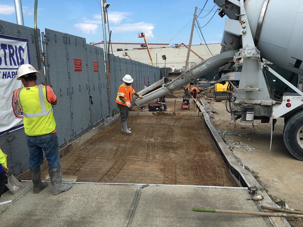 Concreters pouring and screeding a reinforced slab